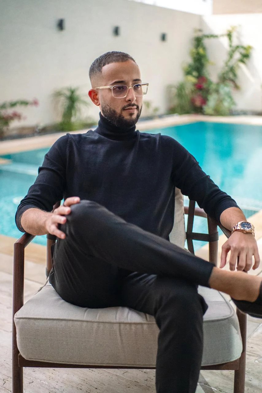 Firas Daas seated beside a pool